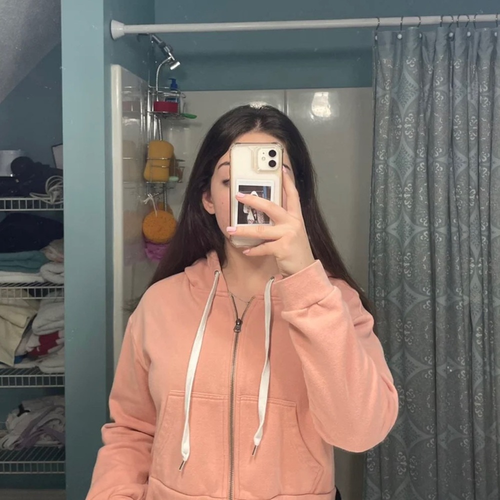 Cropped blush / peachy zip-up hoodie.